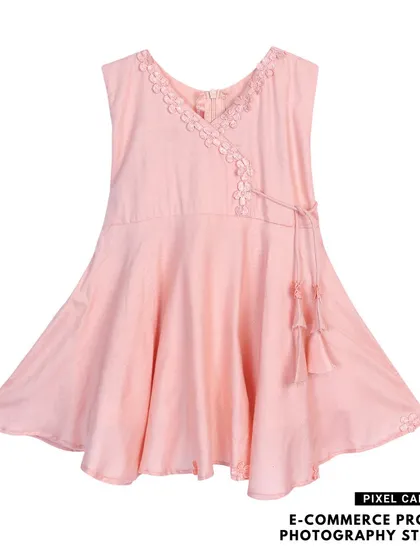A pink baby frock with a tie-up detail, photographed flat on a white background for a clean look.