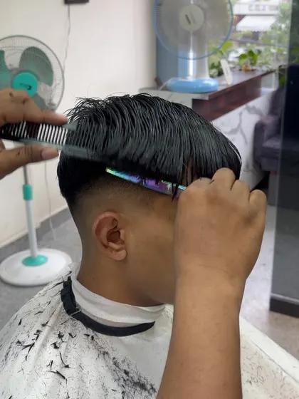 Combing the hair into place to check the lines of the haircut.