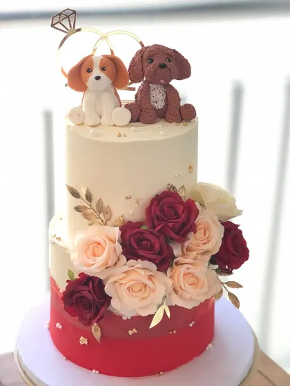 A beautiful two-tiered engagement cake that includes the couple's fur babies. The handcrafted dog toppers add a wonderfully personal touch.