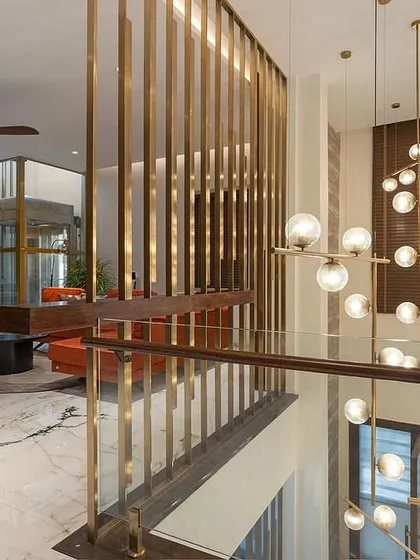The Family Lounge furniture by WIBN. Celebrating the essence of this space's design! The chandelier continues to shine as the highlight on this floor, while the family lounge is adorned with a serene green onyx altar. A pop of joyful orange on the couch reflects the client's love for color, and don't forget to take in the allure of the stunning black and gold TV unit.