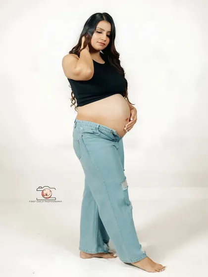 A simple, full-length portrait of the mother-to-be in a casual outfit. This shot focuses on the natural beauty and shape of her body during pregnancy.