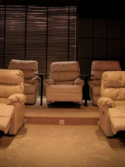 A beautiful setup featuring rows of comfortable, off-white leather recliners. This clean and luxurious look is perfect for a modern and sophisticated home theater.