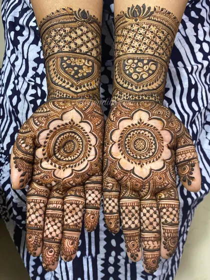 A beautiful combination of a large floral mandala on the palm and a geometric cuff on the wrist.