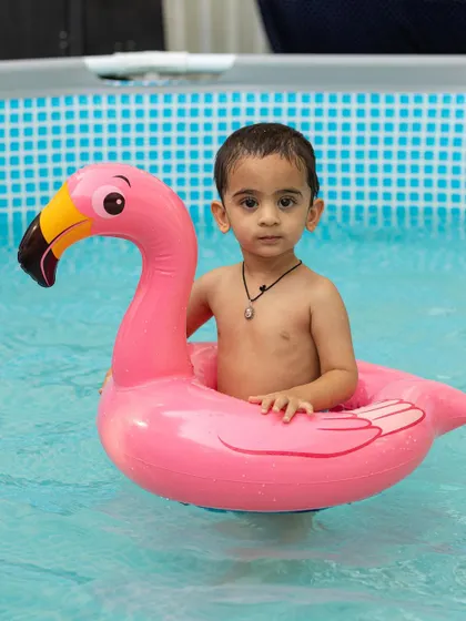 Floating on a pink flamingo is the definition of a perfect pool day for this little one.