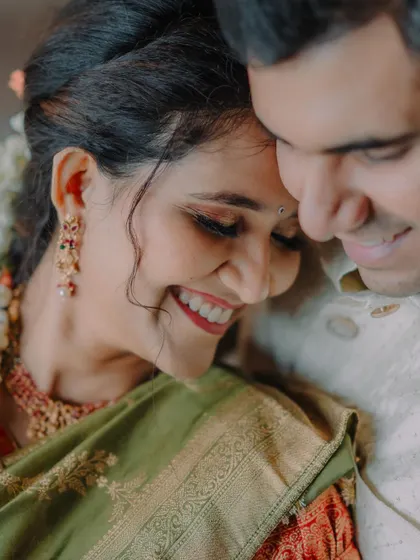 A close-up, tender moment between the bride and groom, their smiles radiating happiness during their temple wedding in Karnataka.