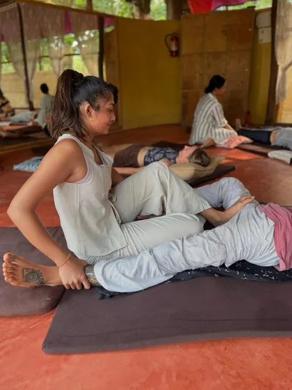 Using my body weight to apply gentle, consistent pressure to the leg. This is a core principle of Thai massage, using leverage instead of muscular force.