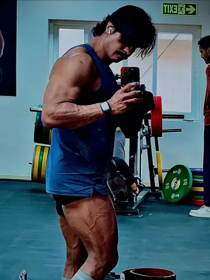 A gym selfie showing highly developed and vascular legs. We don't skip leg day; we build them to be a foundation of strength and aesthetics.