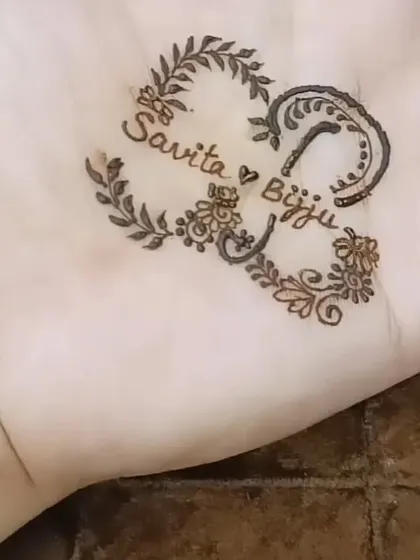 A heart-shaped design created with the initials 'S' and 'B' on the palm.