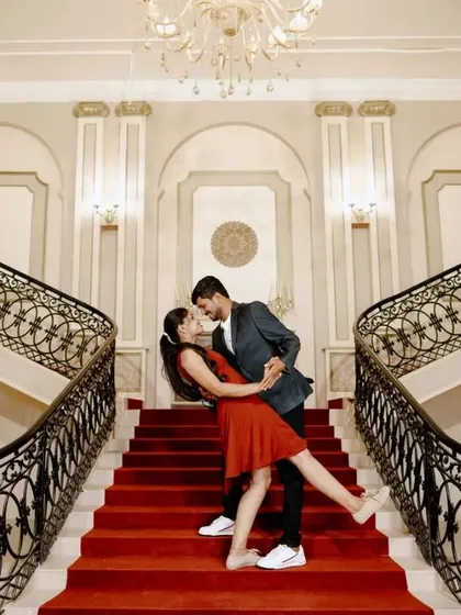 A fun, romantic dip on the stairs. This couple chose a short red dress and a suit for a stylish and playful pre-wedding photo.