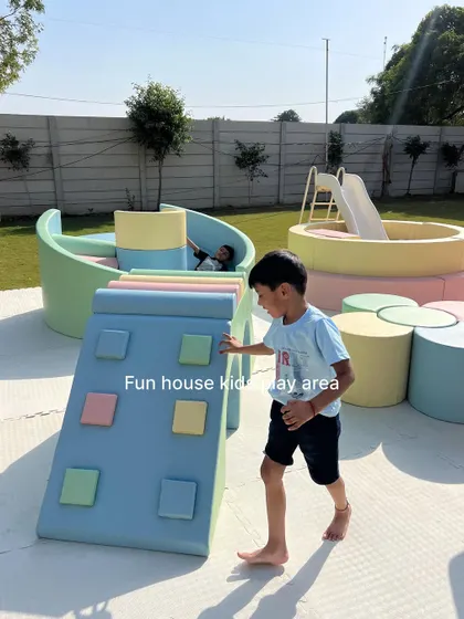 A young explorer tackles the pastel climbing wall, one of the many engaging activities included in our play areas.