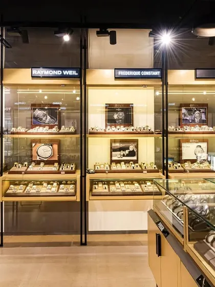 Wall-mounted, illuminated display cases for various luxury watch brands. Each brand has its own dedicated, individually lit section to maintain brand integrity.