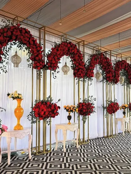 A side angle of the red rose backdrop, highlighting the depth created by the golden frames and the hanging decorative lamps.