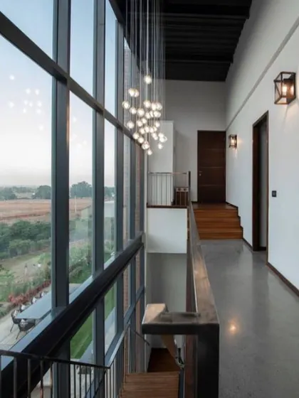 This is a duplicate of ID 75. A view from the upper-level corridor, looking down into the main living area with its cascading chandelier and large windows.