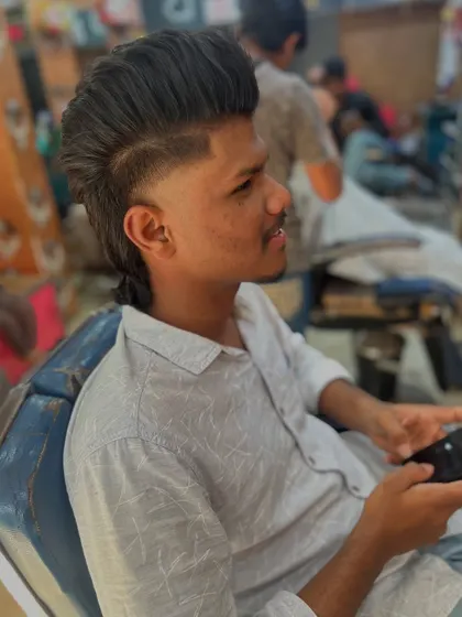 This angle shows how the mullet style is constructed, with a high fade, a hard part for definition, and textured length at the back.