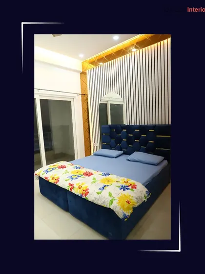 A luxurious bedroom design featuring a tufted blue velvet headboard and a striking accent wall with vertical white and black slats.