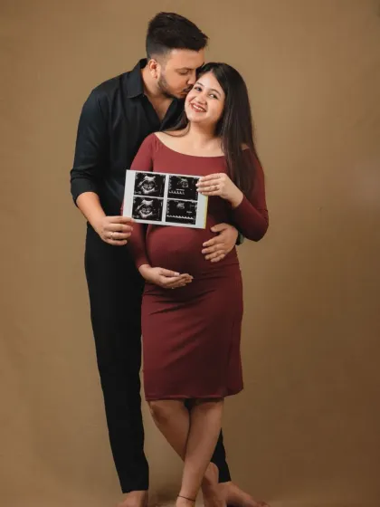A proud couple showcasing their baby's first sonogram pictures. Incorporating the ultrasound scan into the maternity shoot is a wonderful way to connect the before and after of your pregnancy journey.