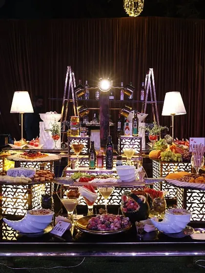 An event is an experience for all senses. This lavishly lit counter, displaying a curated selection of appetizers and drinks, shows our commitment to making every detail, including the food presentation, a visual delight.