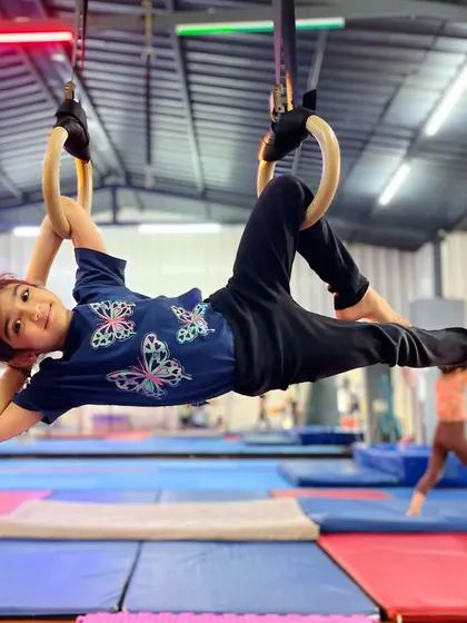 Hanging out and getting strong. This little champion is all smiles while building her skills on the gymnastic rings, proving that our classes are as fun as they are effective.