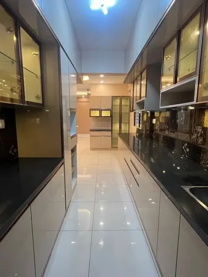 Another perspective of the luxurious galley kitchen, showcasing the extensive storage and the reflective, high-end finishes used throughout.