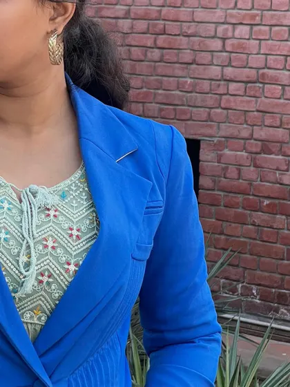 A detail shot of the layering in my chic western outfit. You can see the texture of the embroidered inner top against the smooth fabric of the royal blue blazer.