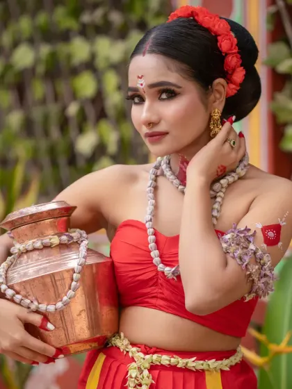 A beautiful portrait of a model in a traditional red outfit, holding a copper pot, embodying a classic Indian aesthetic.