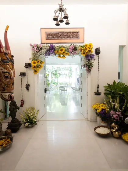 A wider view of the stunning entrance, showcasing the blend of traditional Indian art pieces like the Nandi head with the fresh, vibrant floral decor.