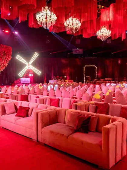 This perspective showcases the relationship between the different elements: the comfortable lounge seating, the formal guest chairs, the whimsical windmill, and the dramatic floral tree.