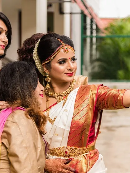 A bride and her tribe. Capturing a selfie moment, this image shows the bride in her classic white and red South Indian saree, surrounded by her friends.