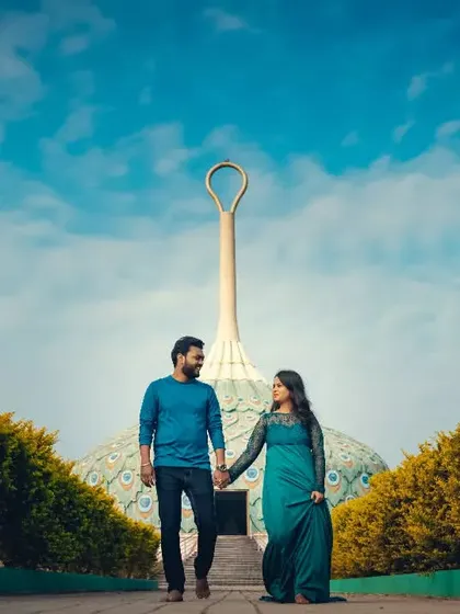 A couple walks hand-in-hand away from a unique architectural dome, creating a sense of journey in this pre-wedding shot.