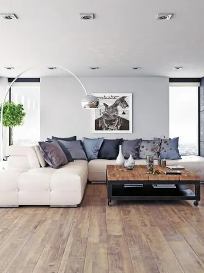 This modern living room features a light, rustic-style wooden floor that provides a warm contrast to the cool gray and blue tones of the decor. The flooring adds texture and a relaxed, contemporary feel.