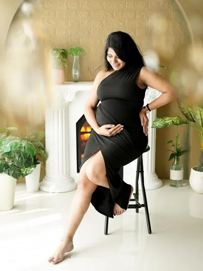 A chic and modern solo portrait by our studio fireplace. The elegant black dress and confident pose make for a stunning image.