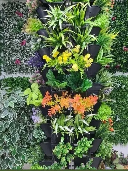 A display showing different options for vertical garden panels. This includes modular planters for real plants and various styles of artificial green wall tiles to suit different tastes and requirements.