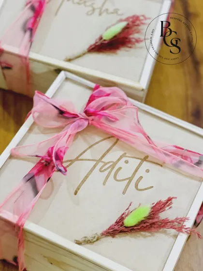 A close-up of the personalized wooden box for a bridesmaid proposal. The elegant script of the name 'Aditi' and the delicate floral and ribbon details make it a cherished keepsake box.