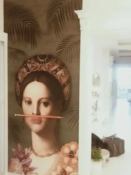 An eclectic and artistic wallpaper combining a portrait with tropical leaves, perfect for making a bold and unique design statement.