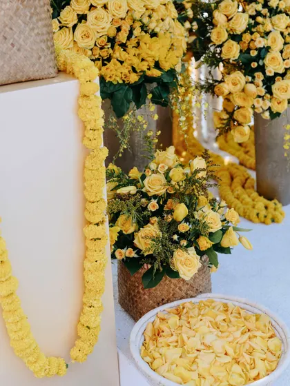 A bowl of fresh marigold petals and a long garland, essential elements for the Haldi rituals.