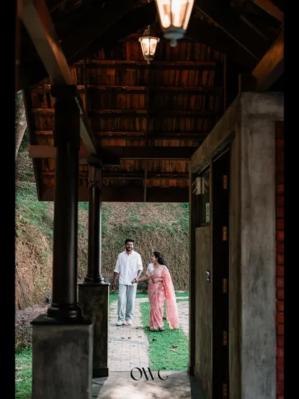 A beautifully framed shot of a couple walking hand-in-hand, seen through a traditional wooden corridor.