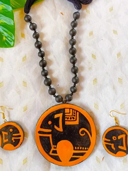 An elephant motif hand-painted in a folk-art style on a round terracotta pendant. Animal motifs are very popular and add a touch of rustic charm to any jewelry collection.