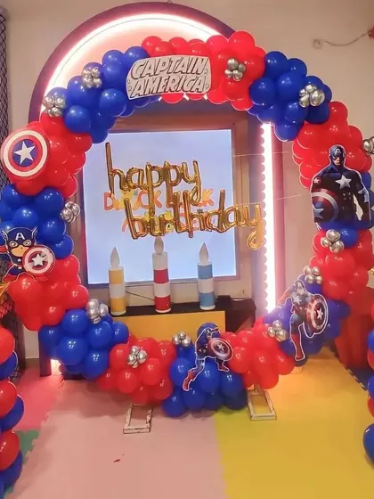 An action-packed Captain America themed birthday. The circular balloon arch in red and blue is decorated with the hero's shield emblem.