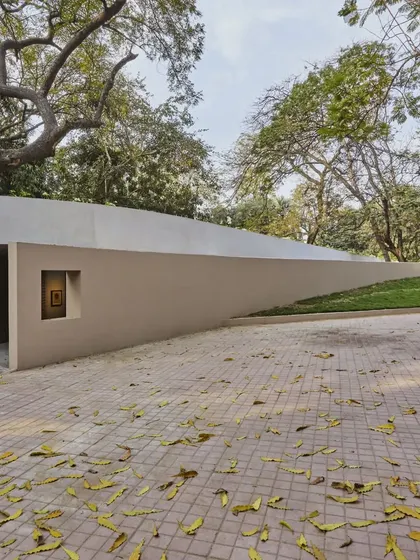The entrance to the subterranean gallery at the Kasturbhai Lalbhai Museum is a discreet opening in the landscape. This design allows the new extension to exist without visually compromising the sightlines of the historic mansion on the site.