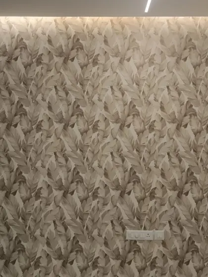 A full view of a wall with a neutral-toned, large-scale leaf pattern. The design adds texture and a modern organic feel, making the room feel spacious and stylish.