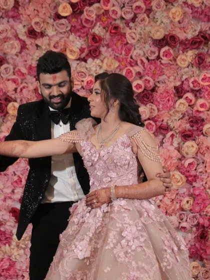 A candid and joyful moment of the couple dancing at their engagement. Set against a vibrant wall of flowers, this photo captures their natural chemistry and the fun atmosphere of the celebration.