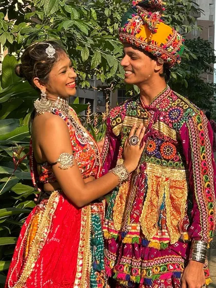 A close-up look at the beautiful coordination. The man's pagdi and the woman's jewelry perfectly complement their vibrant, embroidered outfits.