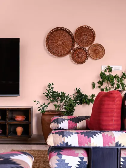 In this family lounge, we used refurbished sofas with vibrant, patterned fabric and simple cane baskets on the wall for a wabi-sabi inspired, imperfectly beautiful look.