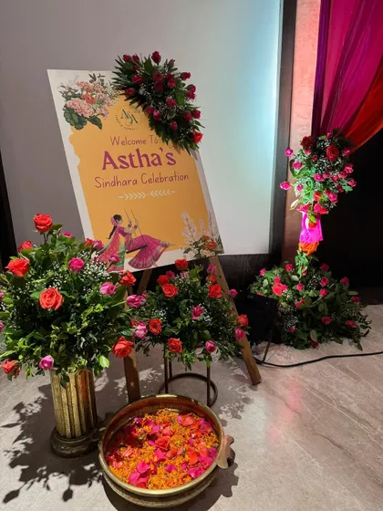 Personal touches make an event special. I designed this custom welcome sign for the 'Sindhara' celebration, surrounded by fresh flowers that matched the event's color scheme. A bowl of petals was kept for guests to shower their blessings.
