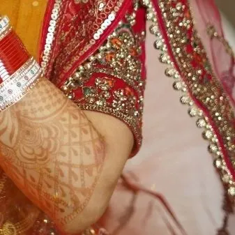 A close-up of the bride's chooda (bangles) and the embroidery on her blouse. These details are an essential part of the wedding story.