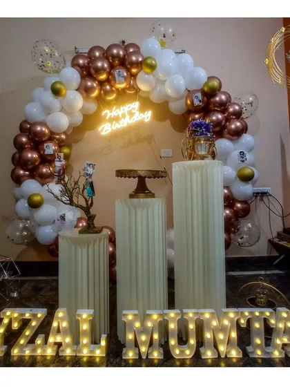 We love creating personalized focal points for your party. This setup features a beautiful balloon arch with marquee letters spelling out the name, making the guest of honor feel truly special.