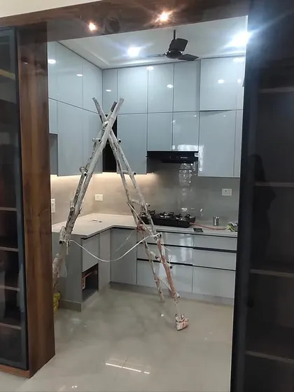 A view from the living area into the nearly finished kitchen, showing how the wooden-framed glass partition creates an open yet separate feel.