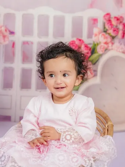 A bright, happy smile from this little girl during her pink-themed sitter session. Her joy is absolutely contagious.