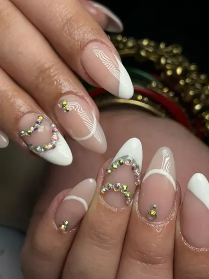 A fun and flirty design with a slanted white French tip and sparkling rhinestone hearts.