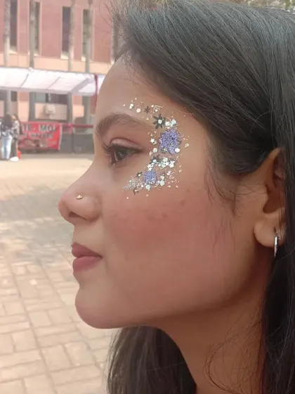 A different take on floral art, using purple glitter to create the shape of flowers along the eye.